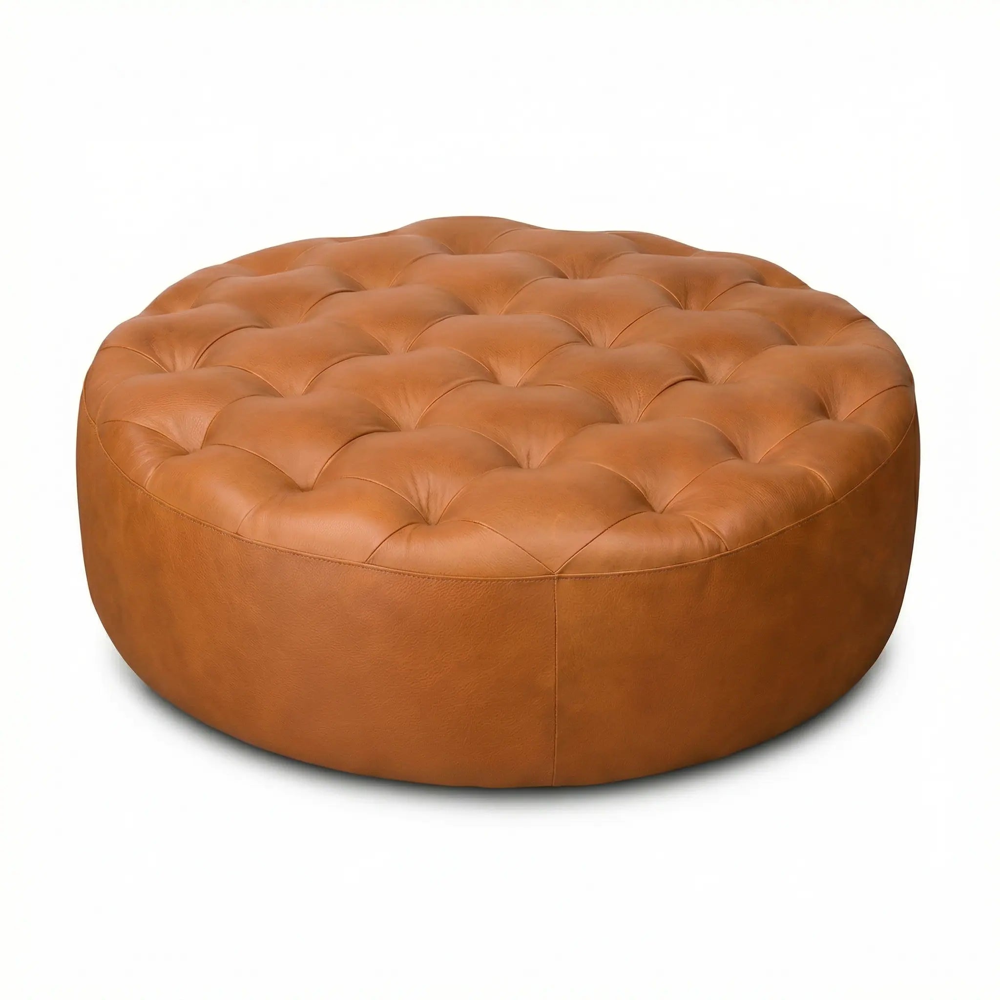 Moroccan Leather Pouf Tan leather ottoman in a living room setting with a beige sofa and plant.