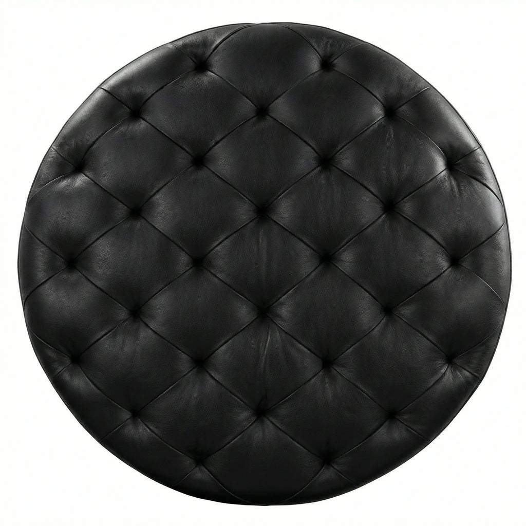 Moroccan Leather Pouf black leather ottoman in a living room setting with a beige sofa and plant.