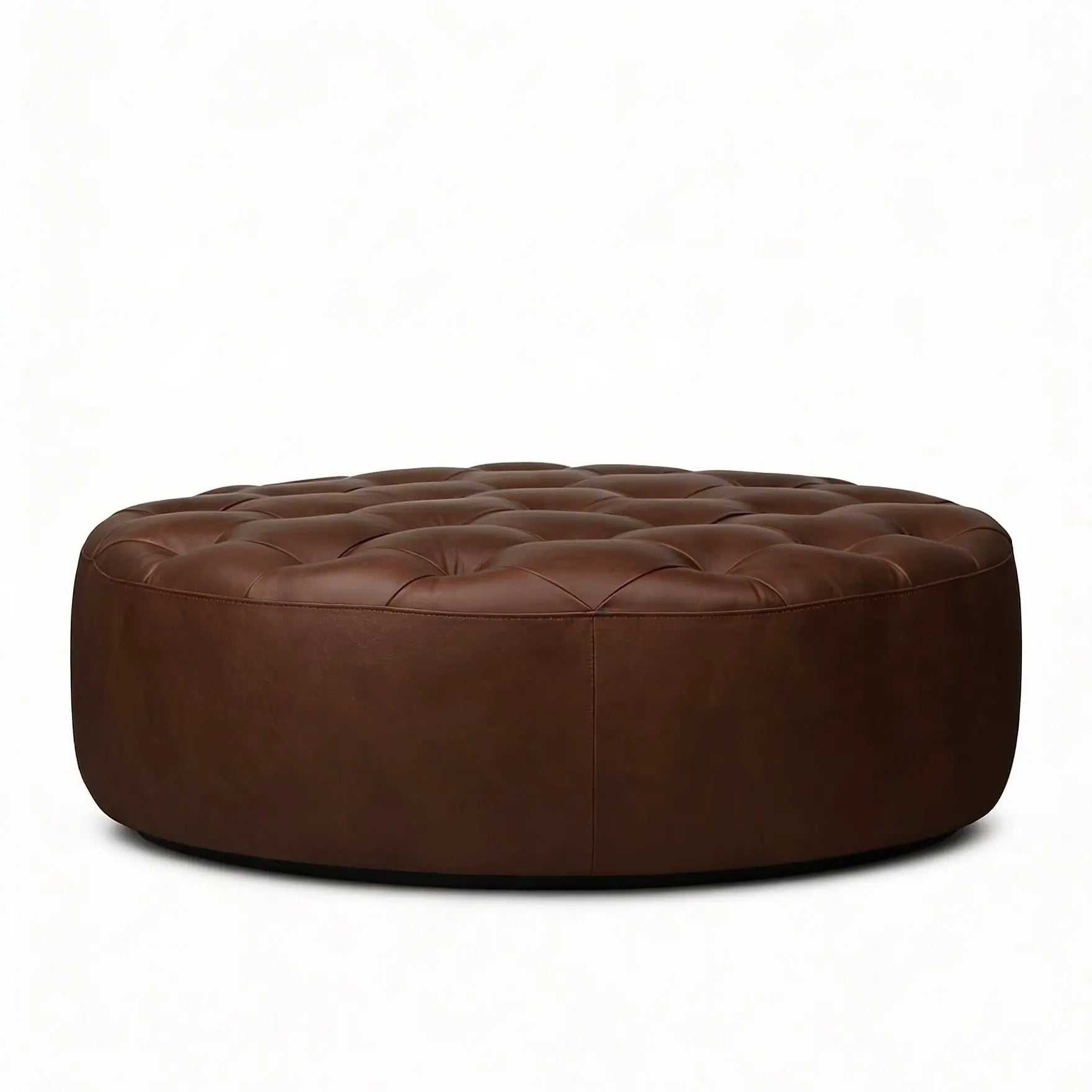 Moroccan Leather Pouf Dark Brown leather ottoman in a living room setting with a beige sofa and plant.