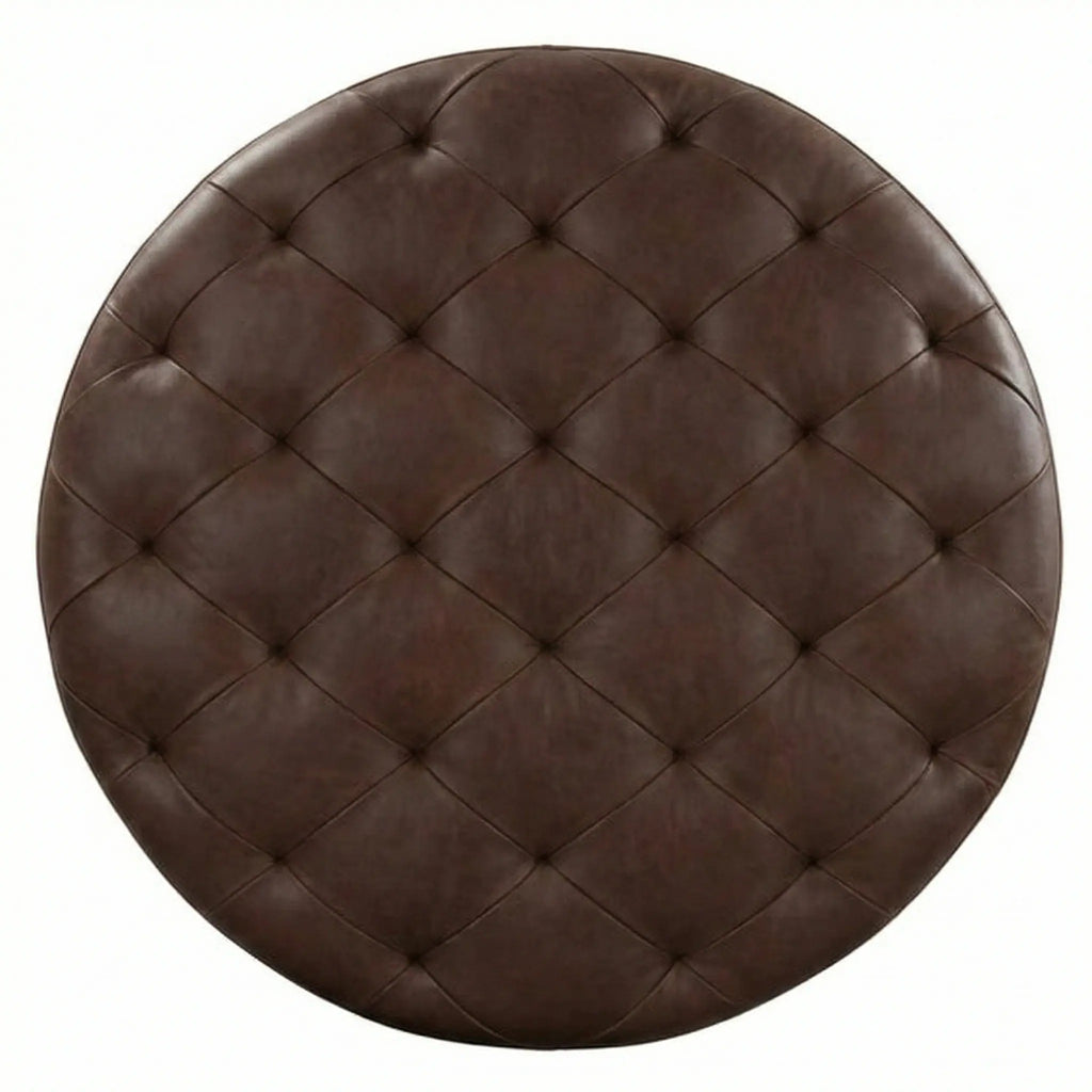 Moroccan Leather Pouf Dark Brown leather ottoman in a living room setting with a beige sofa and plant.